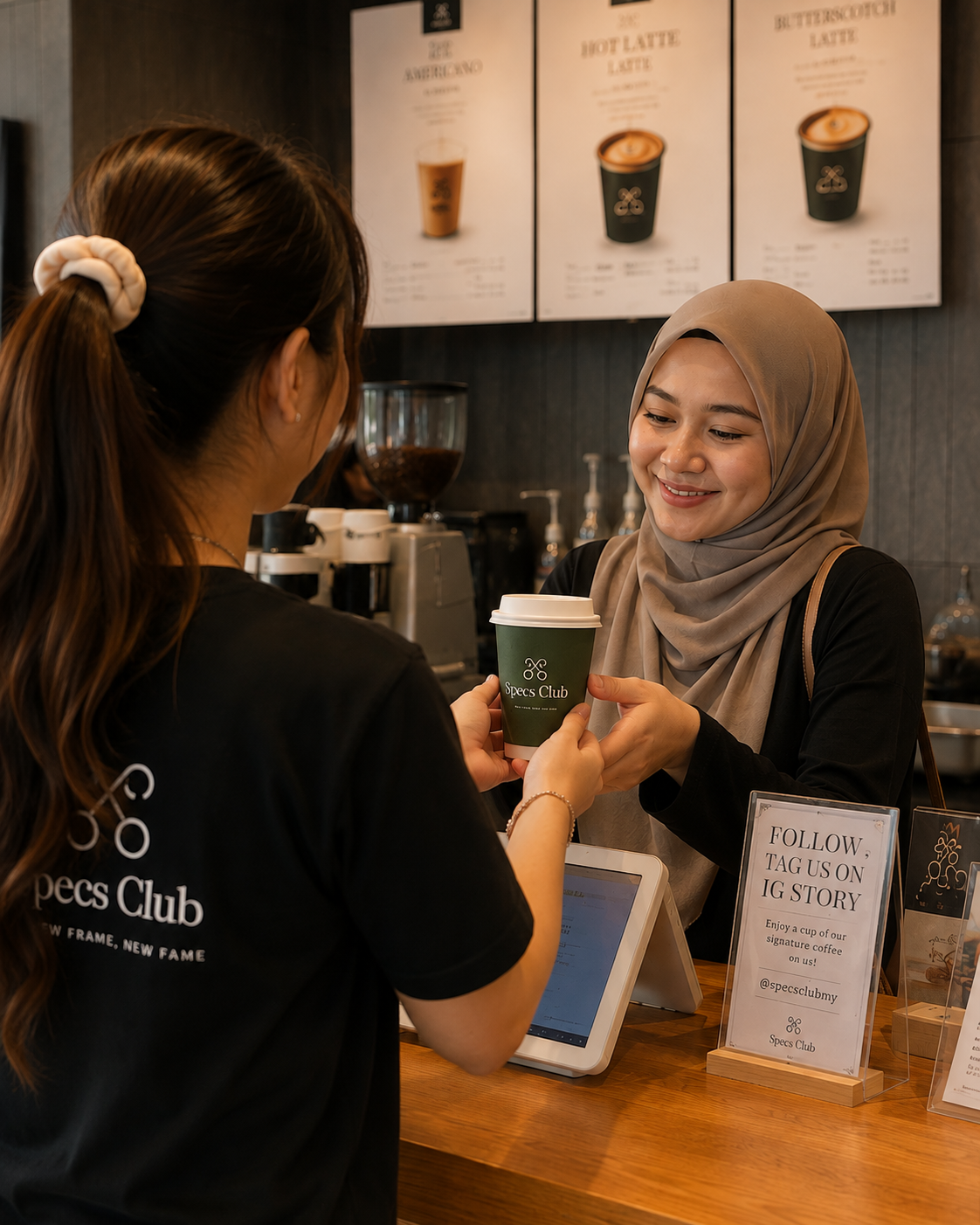 Specs Club team member serving coffee to a customer at the café counter